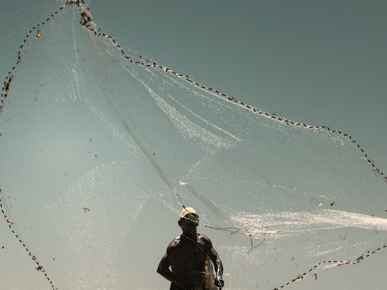 Pescador lançando a tarrafa