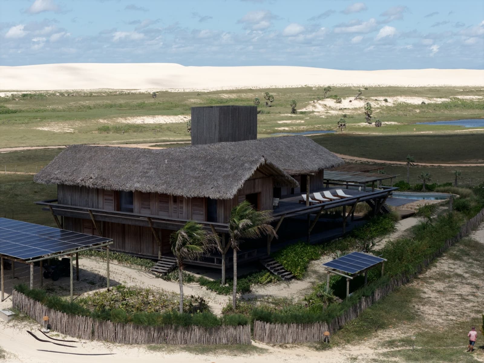 Casa off-grid de Moréias vista do alto, com as placas solares e as dunas ao fundo