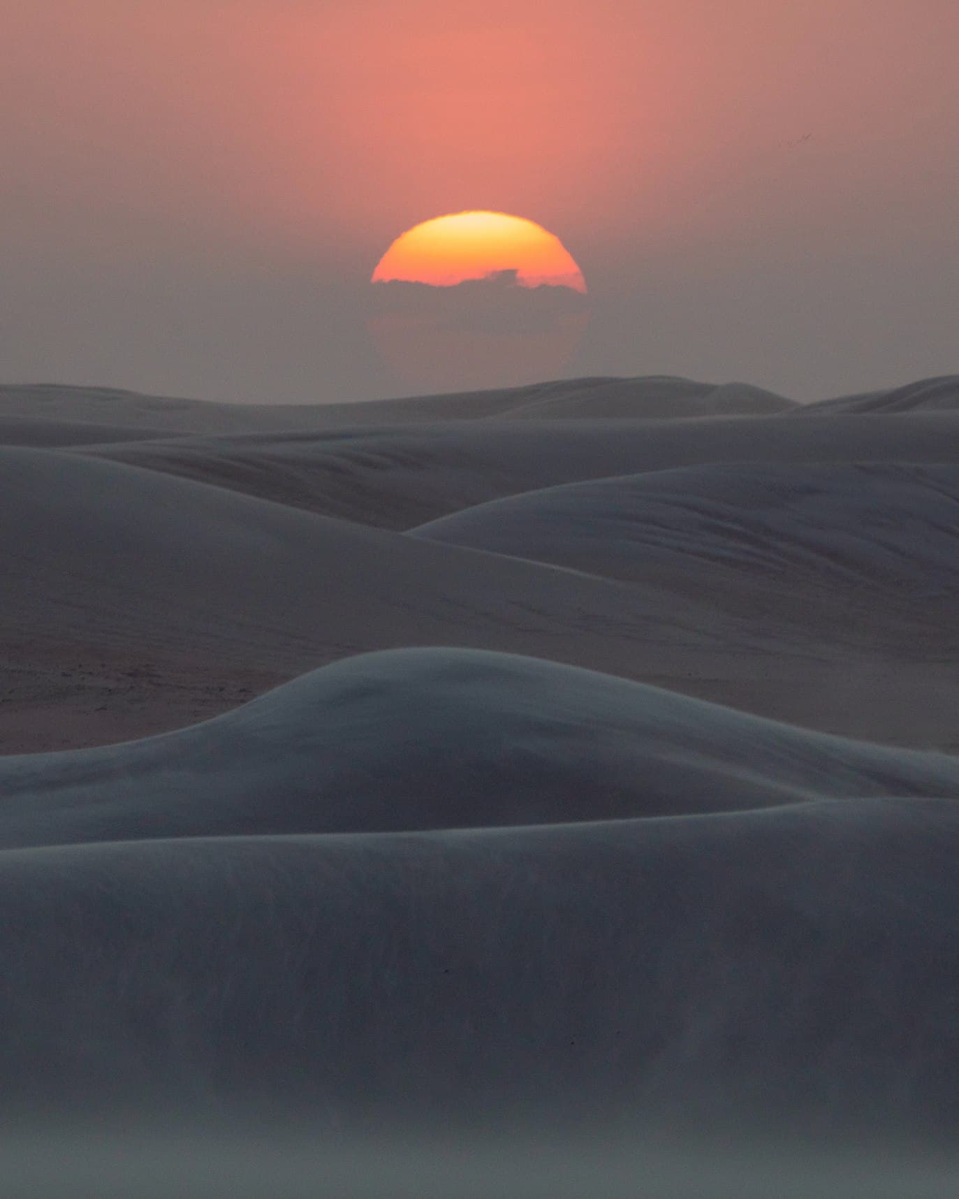 O sol se pondo atrás das dunas de Moréias