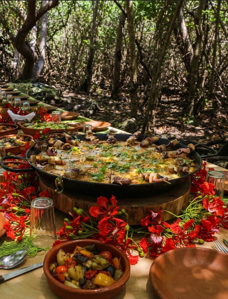 The winter paella on the long table, among flowers and the mangrove